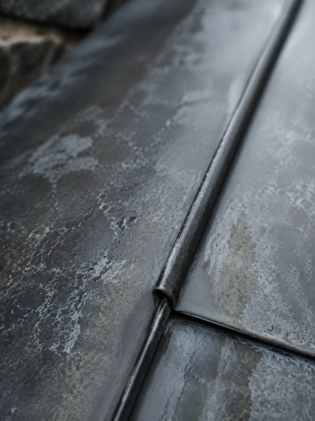 Gros plan sur une jonction de zinc patiné